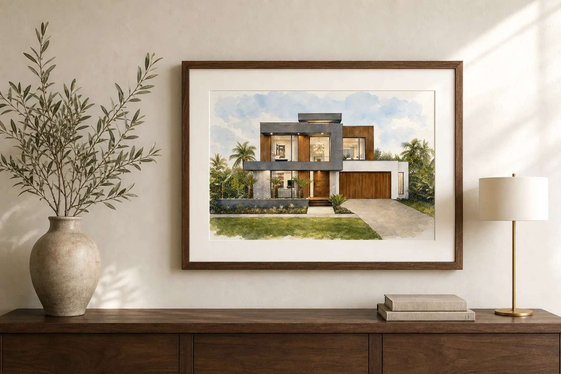 A framed watercolour home portrait displayed above a walnut console